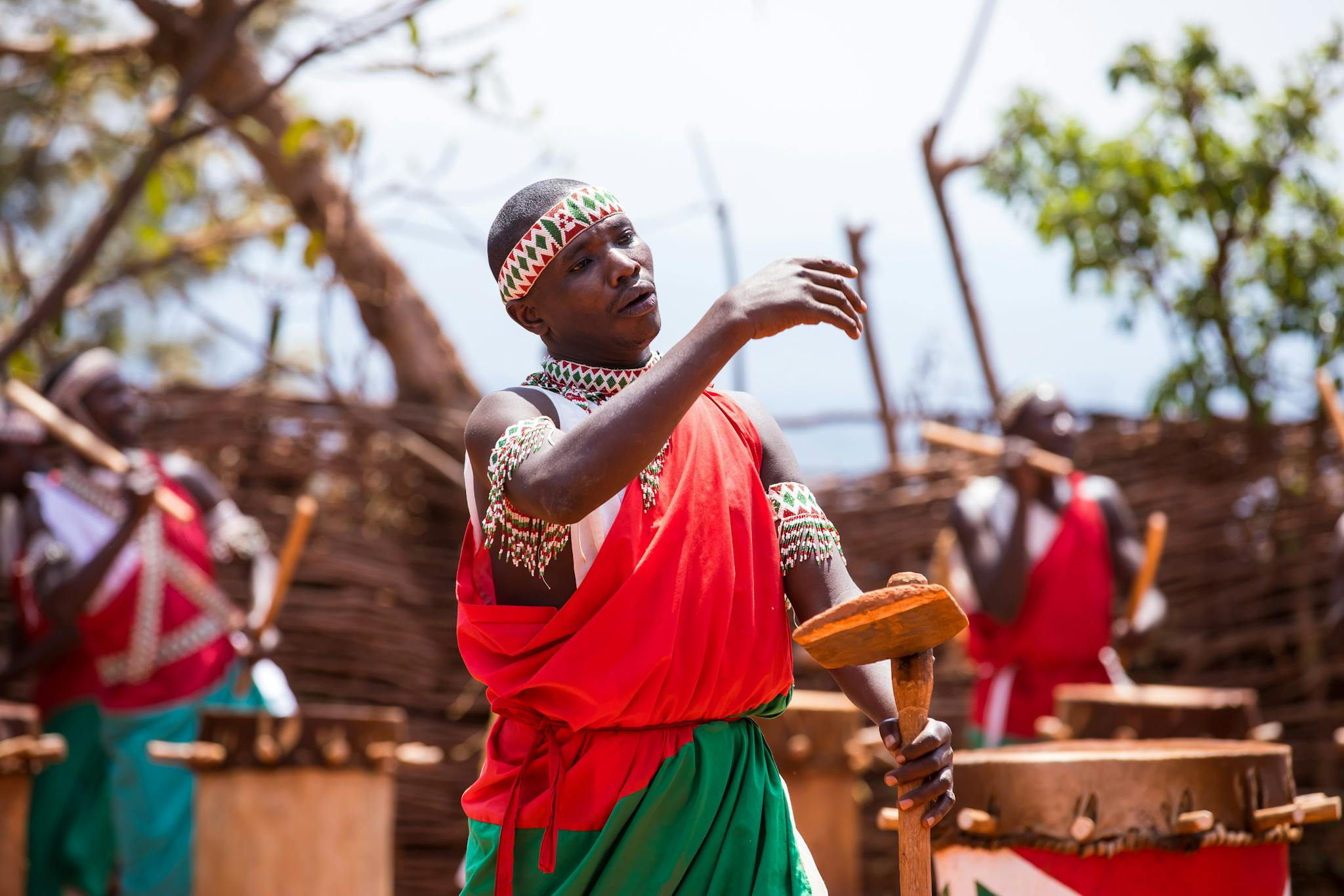 Men in colorful traditional costumes perform an energetic African drum festival.